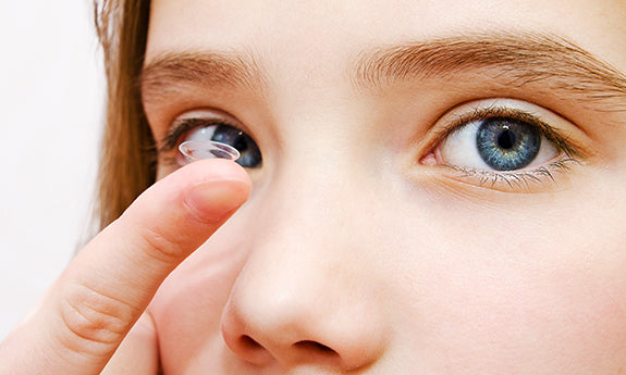 Person preparing to wear a contact lens